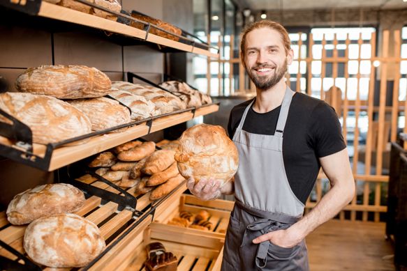 Billy, a baker, holding a fresh loaf